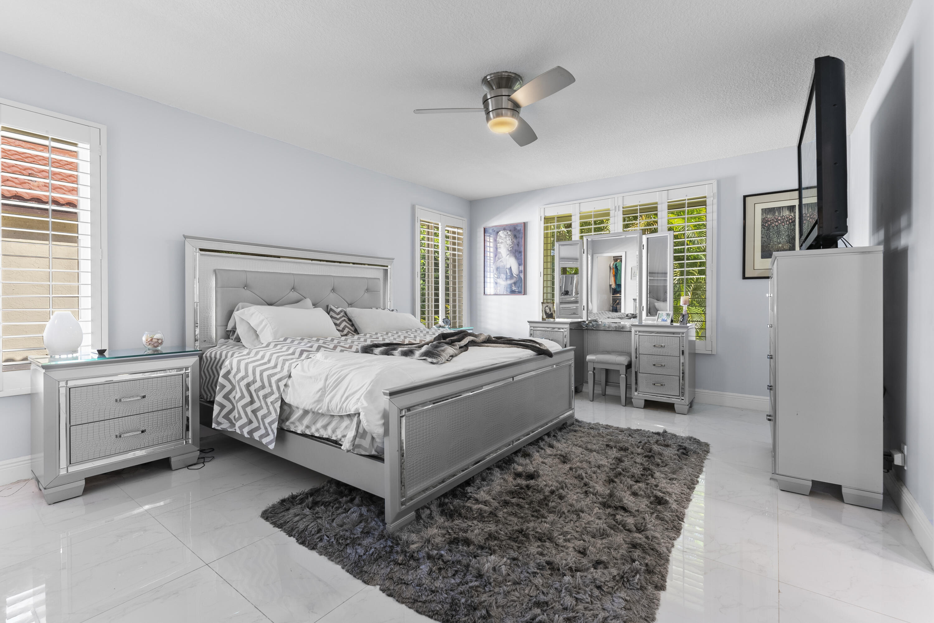334 Northwest 42nd Street Boca Raton, FL 33431 - Photo 29 of 48 a spacious bedroom with a bed and a chandelier