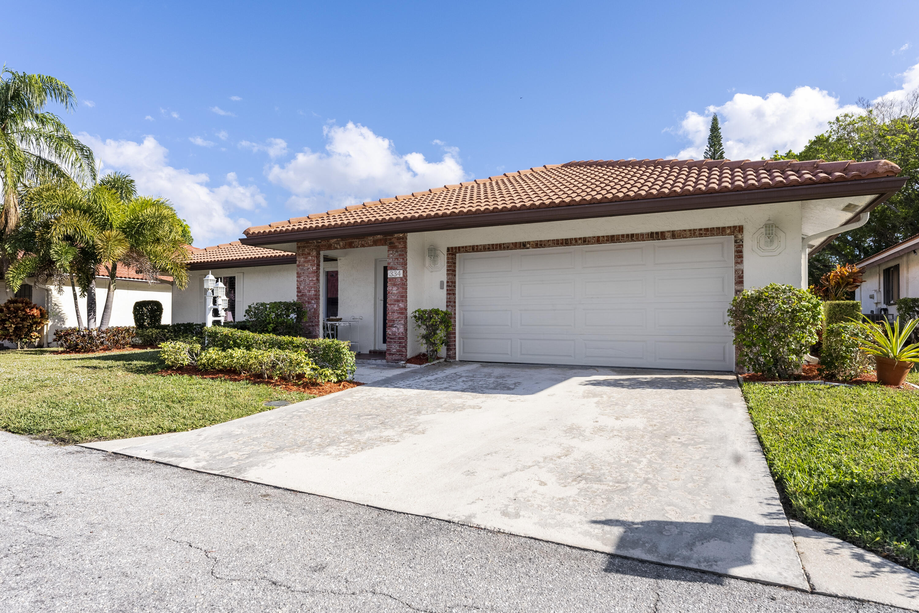 334 Northwest 42nd Street Boca Raton, FL 33431 - Photo 4 of 48 a front view of a house with a yard and potted plants