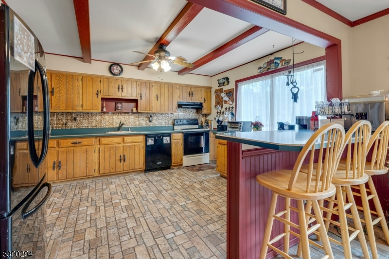 305 Wykertown Road Branchville, NJ 07826 - Photo 10 of 31 a kitchen with stainless steel appliances granite countertop a sink dishwasher a stove a refrigerator with a dining table and chairs with wooden floor