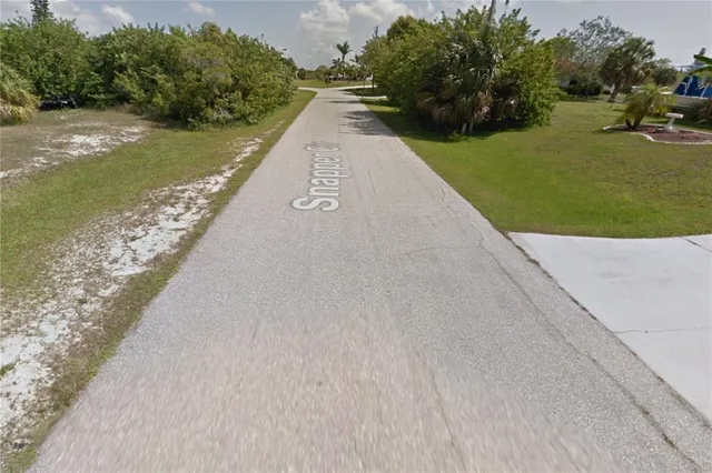 a view of a street with a yard and a fountain