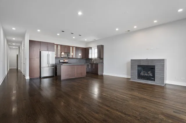 a view of kitchen with wooden floor and a refrigerator