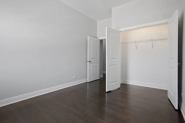 an empty room with wooden floor and white walls