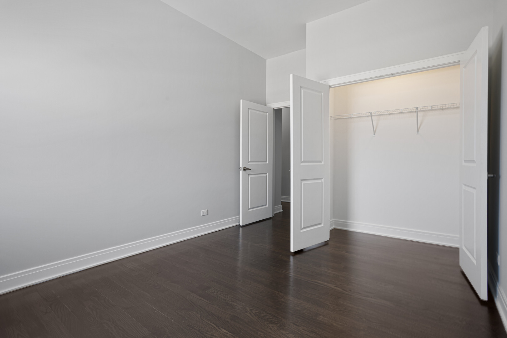 1412 West Morse Avenue, Unit 4B Chicago, IL 60626 - Photo 9 of 16 an empty room with wooden floor and white walls