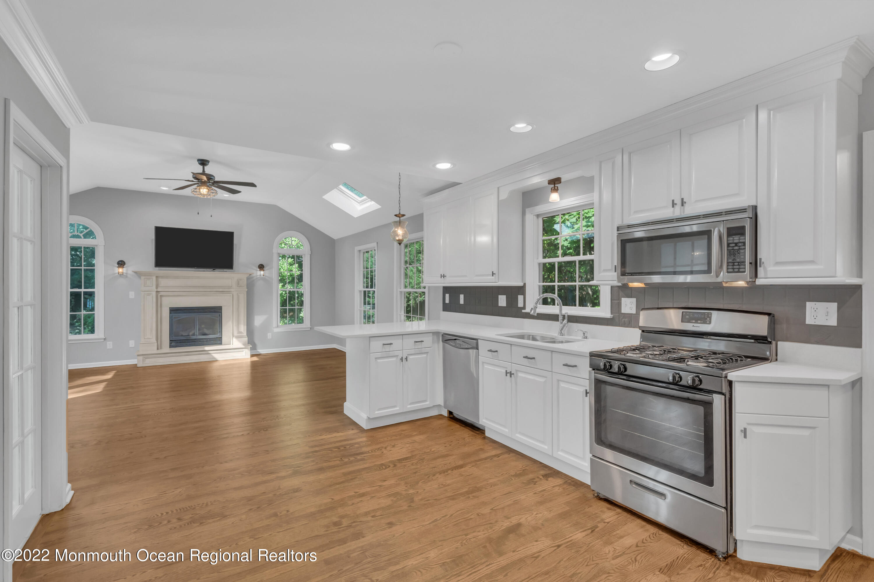 a large kitchen with cabinets wooden floor and stainless steel appliances