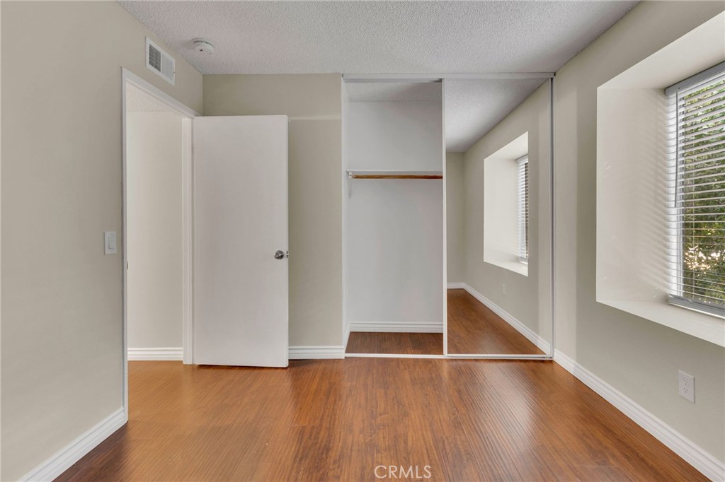 9404 Roundup Drive, Unit B Montclair, CA 91763 - Photo 17 of 37 a view of an empty room with wooden floor and a window
