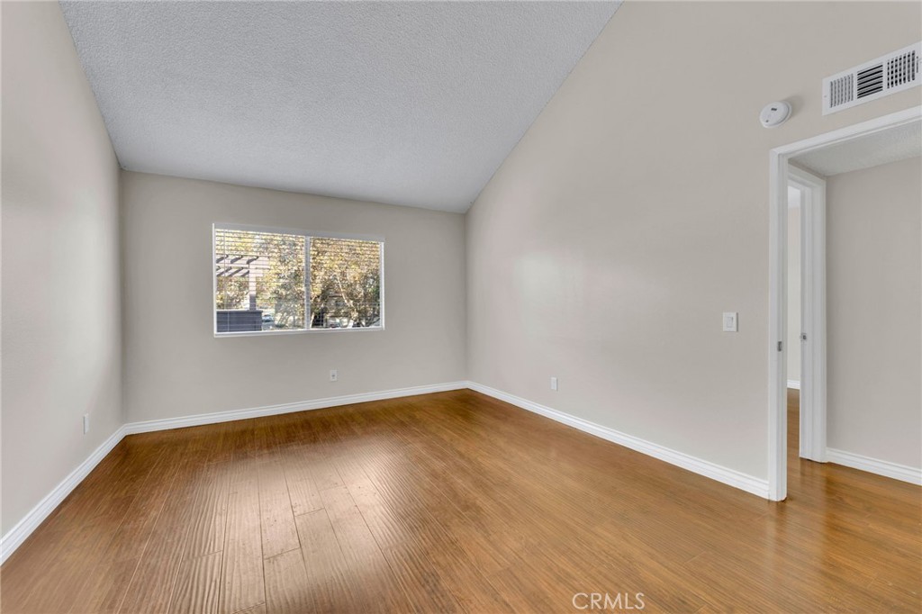 9404 Roundup Drive, Unit B Montclair, CA 91763 - Photo 20 of 37 an empty room with wooden floor and windows