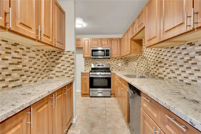 a kitchen with granite countertop cabinets stainless steel appliances and a counter space