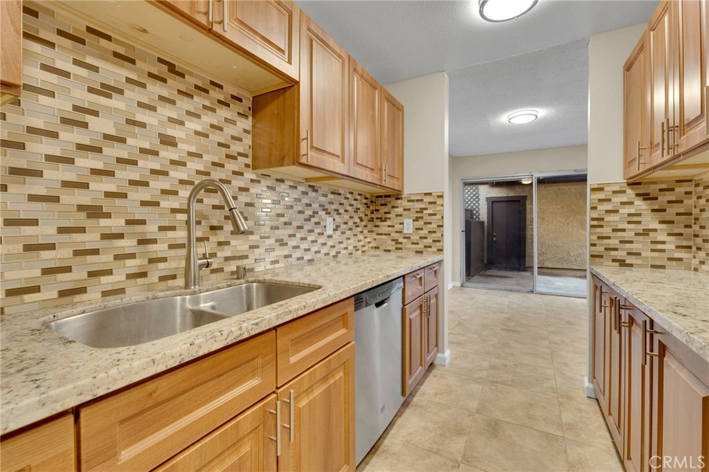 9404 Roundup Drive, Unit B Montclair, CA 91763 - Photo 9 of 37 a kitchen with granite countertop a sink and cabinets