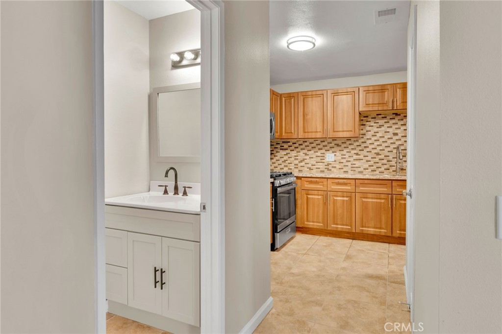 9404 Roundup Drive, Unit B Montclair, CA 91763 - Photo 10 of 37 a bathroom with a granite countertop sink a toilet and a mirror