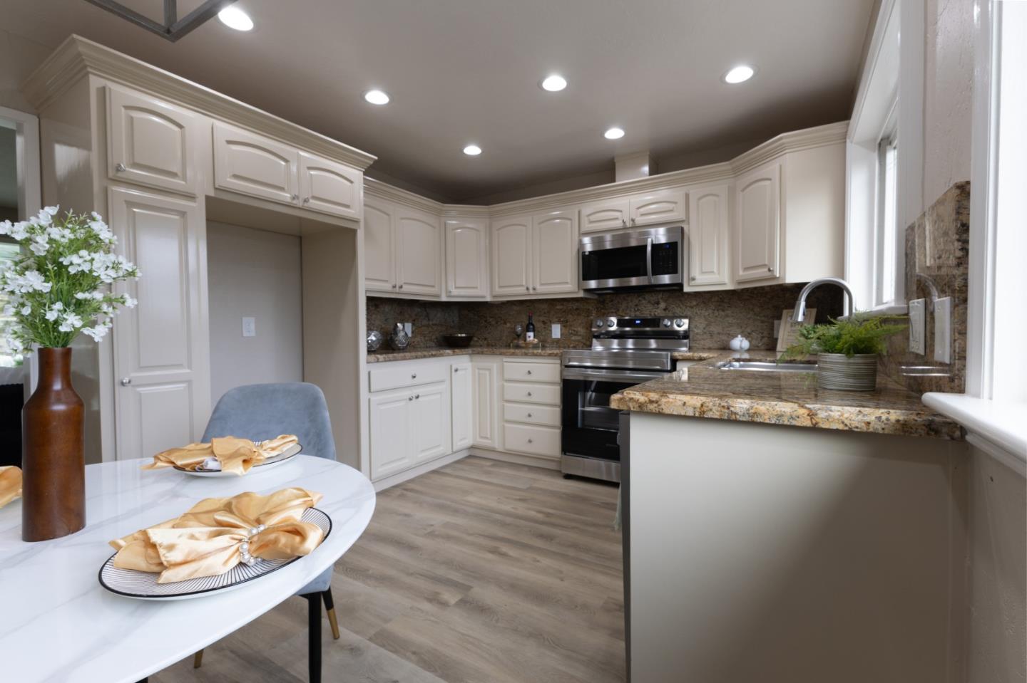 4030 St Marys Street Martinez, CA 94553 - Photo 5 of 28 a kitchen with stainless steel appliances granite countertop a sink a stove a microwave a dining table and chairs