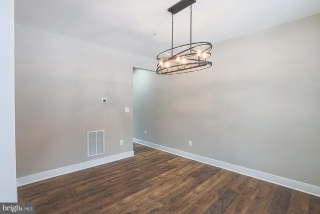 a view of a room with wooden floor chandelier and window