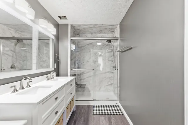 a bathroom with a sink a mirror and a shower