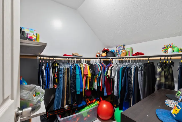a view of walk in closet with clothes and shoes