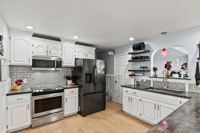 a kitchen with stainless steel appliances granite countertop a refrigerator and a stove top oven