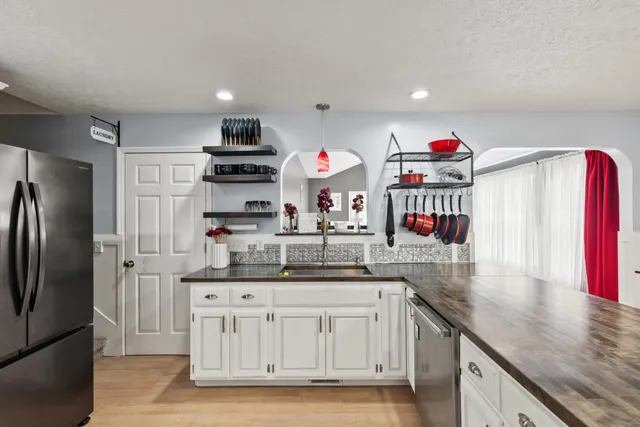 a kitchen with stainless steel appliances granite countertop a sink and a refrigerator
