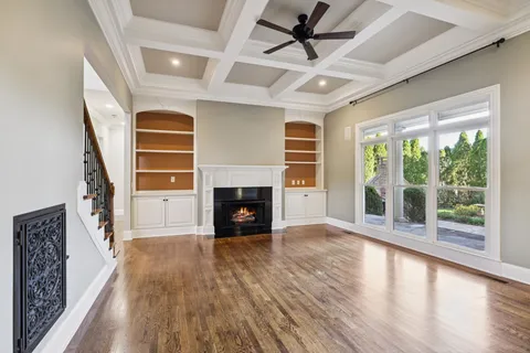 a view of empty room with wooden floor and fireplace