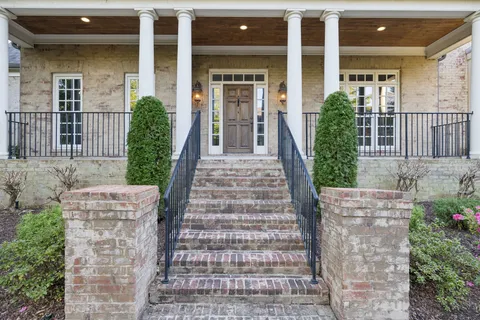 a view of a living room with floor to ceiling window and wooden floor