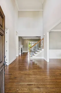 a view of a room with wooden floor table and windows