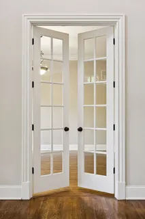 a view of an empty room with wooden floor and a fireplace