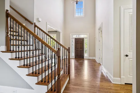 a kitchen with stainless steel appliances granite countertop a refrigerator a sink dishwasher a stove and white countertops with wooden floor