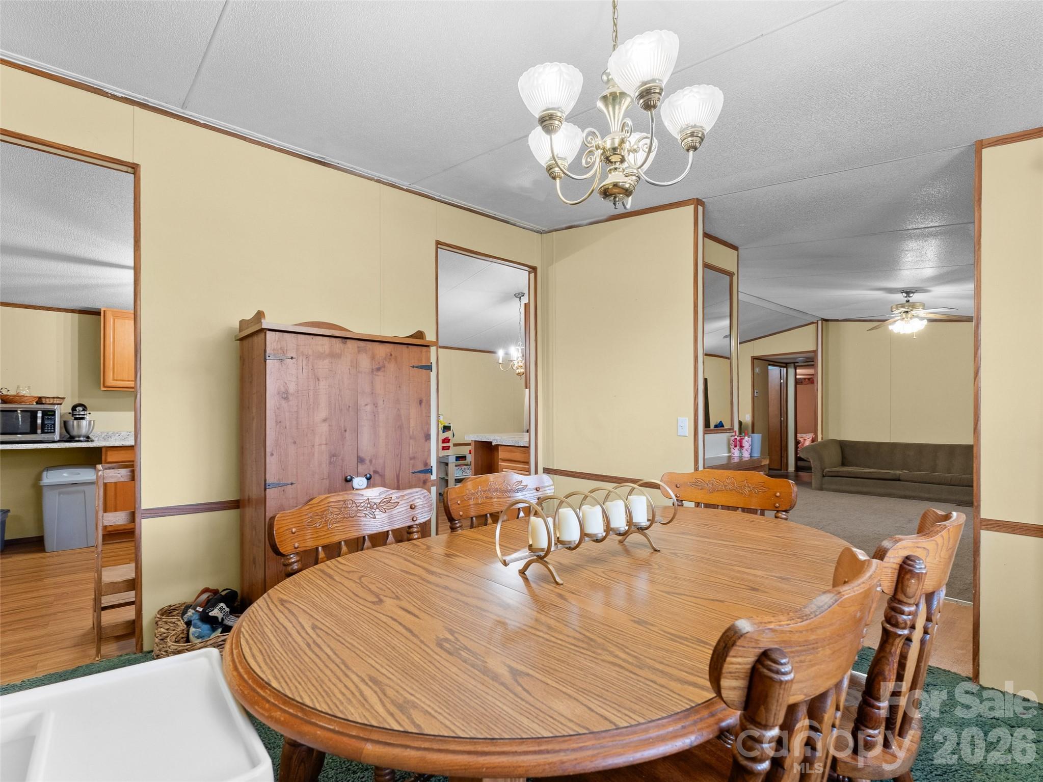 301 Matthew Lane Canton, NC 28716 - Photo 11 of 29 a dining room with wooden floor a chandelier a wooden table and chairs