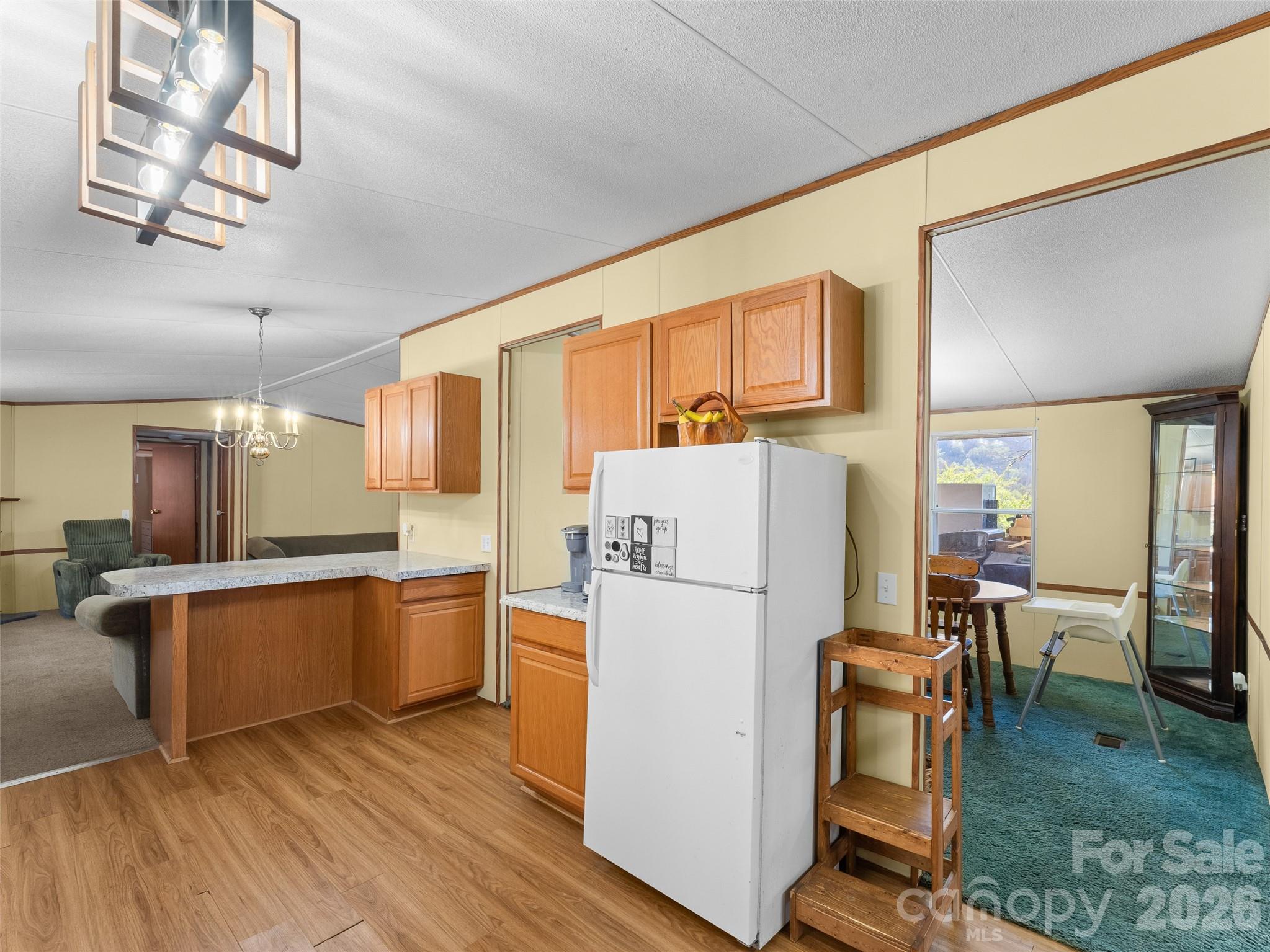301 Matthew Lane Canton, NC 28716 - Photo 7 of 29 a kitchen with stainless steel appliances granite countertop a refrigerator a stove top oven a dining table and chairs with wooden floor