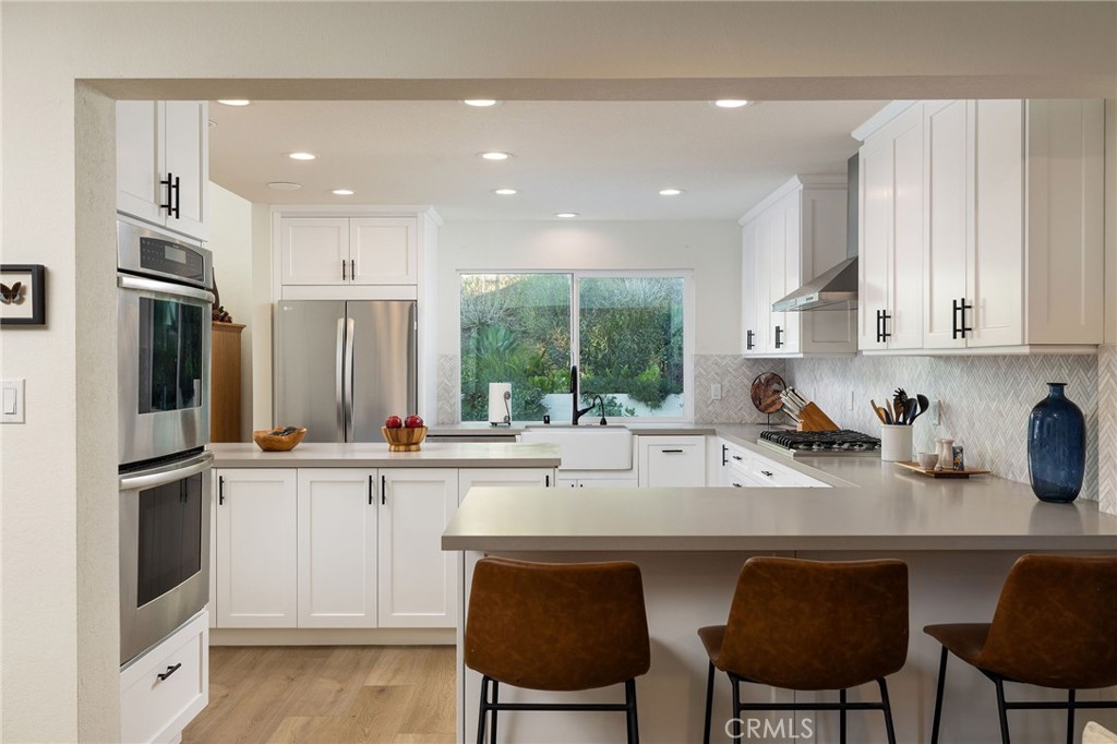 602 Calle Ganadero San Clemente, CA 92673 - Photo 13 of 42 a kitchen with stainless steel appliances granite countertop a table chairs sink refrigerator and cabinets