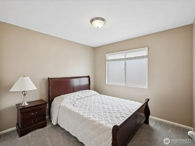 a bedroom with a bed and a lamp on table