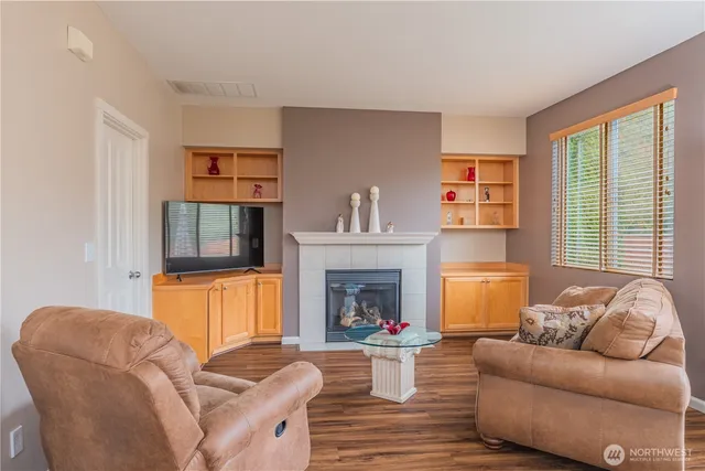 a living room with furniture a fireplace and a large window