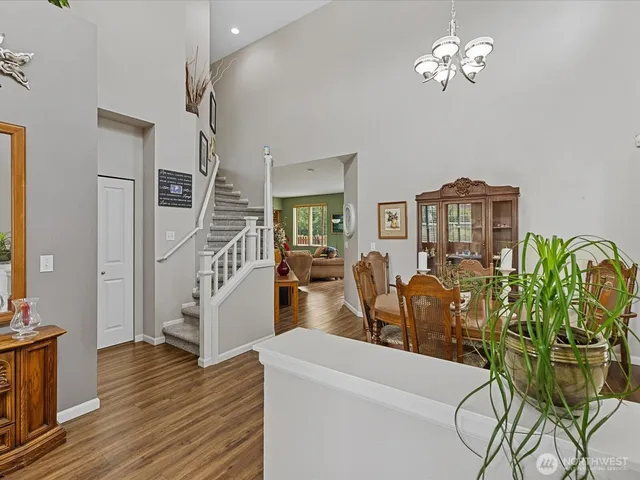 a living room with furniture chandelier and wooden floor