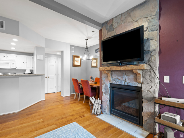 900 Bitner Road, Unit D 34 Park City, UT 84098 - Photo 6 of 25 Living area featuring light wood-type flooring, hanging lights, and a stone fireplace