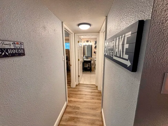 a view of a hallway with wooden floor and staircase