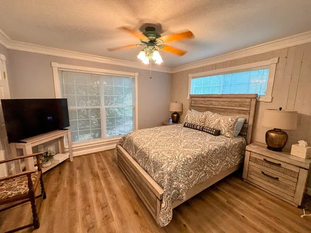 a bedroom with a bed and a flat tv screen on the dresser