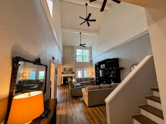 a living room with furniture dining table wooden floor and a fireplace