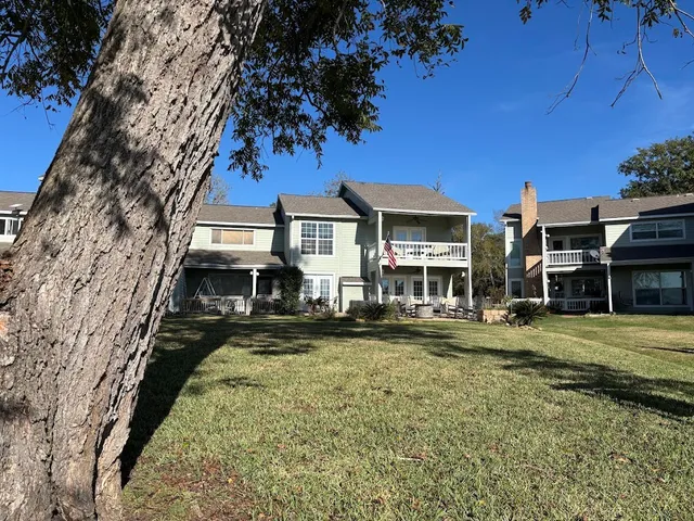 a view of a big house with a big yard and large trees