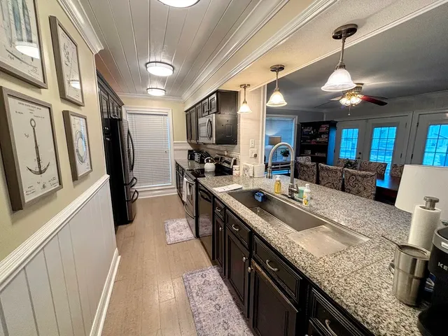 a large kitchen with stainless steel appliances granite countertop plenty wooden cabinets counter space a sink and a stove