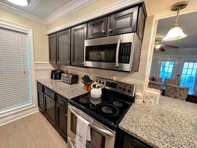 a kitchen with stainless steel appliances granite countertop a stove and a microwave