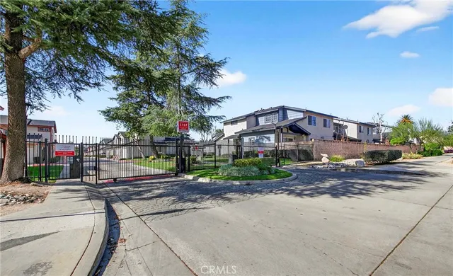 a view of a street with a bench and cars parked