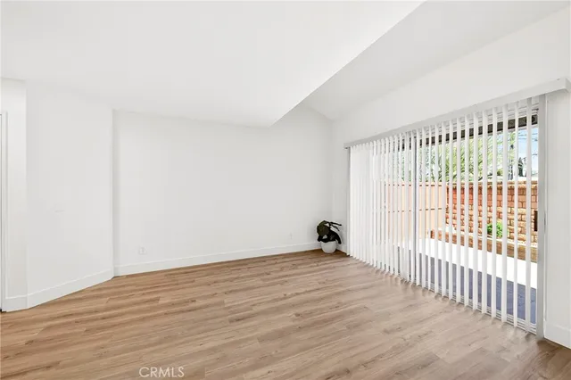 a view of a room with wooden floor and a window