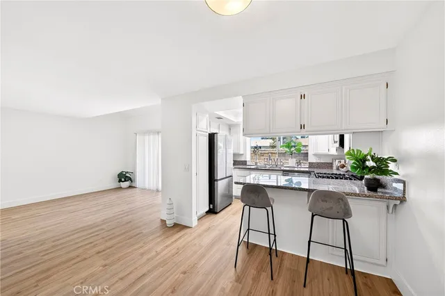 a kitchen with stainless steel appliances a dining table chairs and chandelier