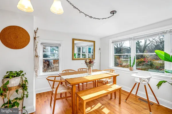a view of a dining room with furniture a chandelier and wooden floor