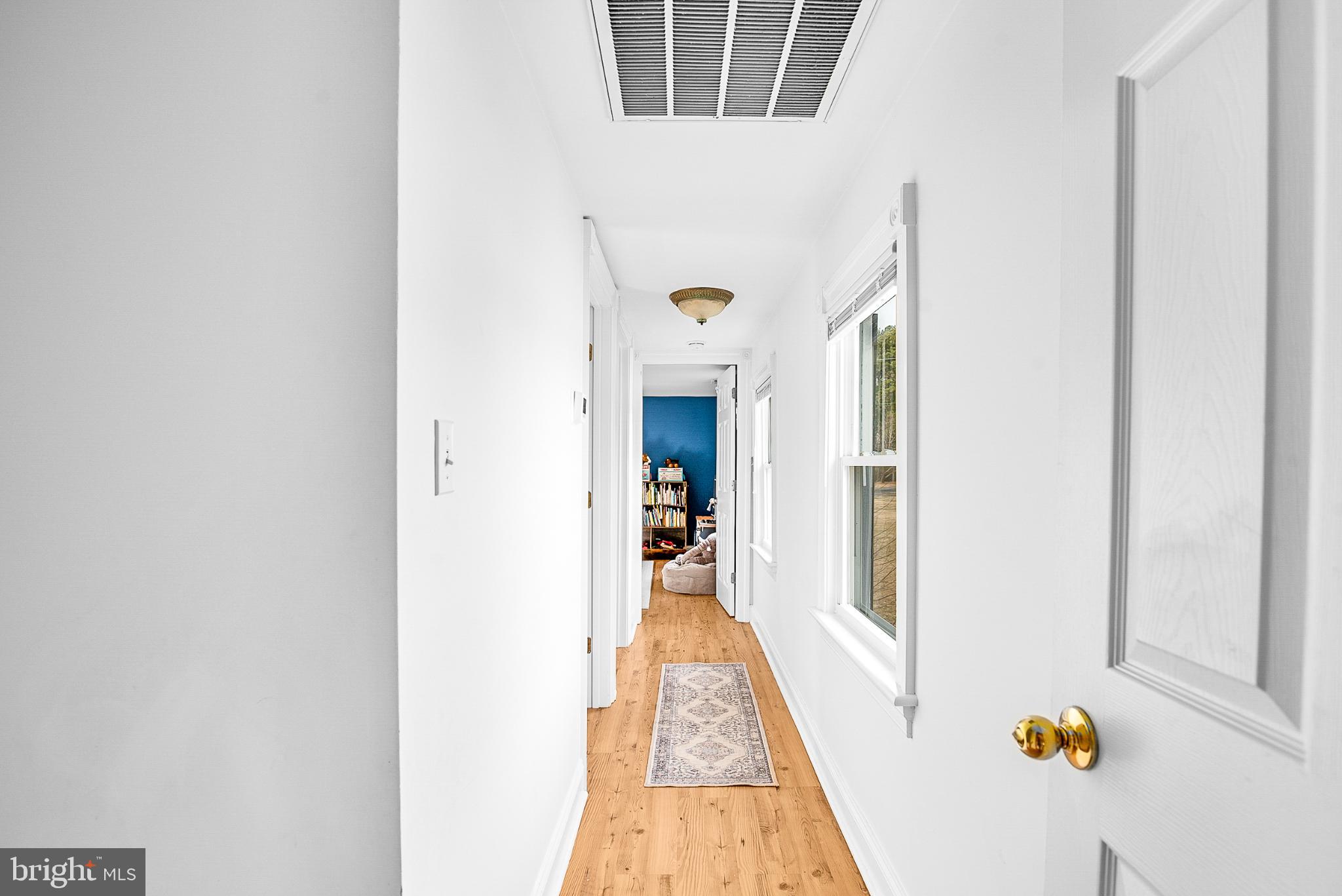 22582 Pot Pie Road Wittman, MD 21676 - Photo 21 of 36 a view of a hallway with wooden floor and staircase
