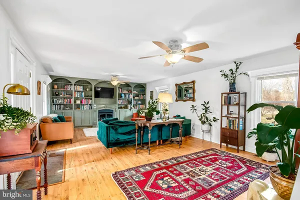 a living room with furniture a chandelier and a dining table with potted plants
