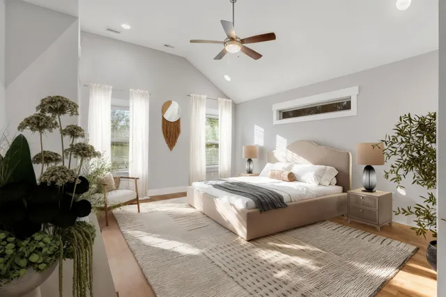 a spacious bedroom with a bed mirror and painting on the wall