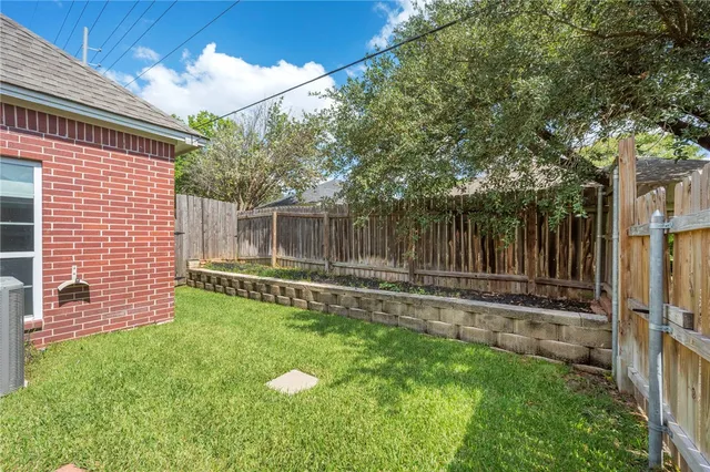 a view of a backyard with table and chairs and wooden fence