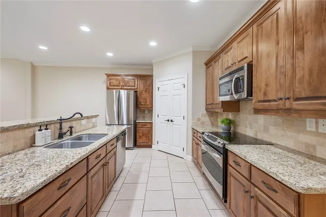 a spacious kitchen with stainless steel appliances granite countertop a sink stove and refrigerator