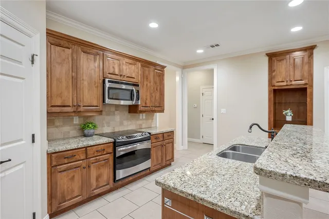 a kitchen with stainless steel appliances granite countertop a stove sink and microwave