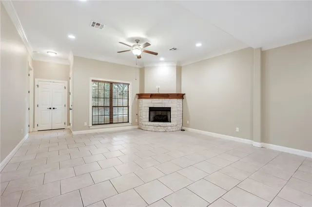 an empty room with windows and fireplace