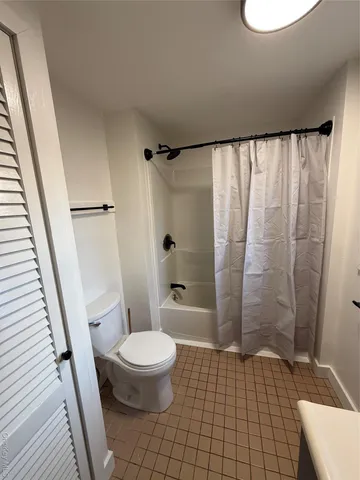 a bathroom with a toilet and a shower