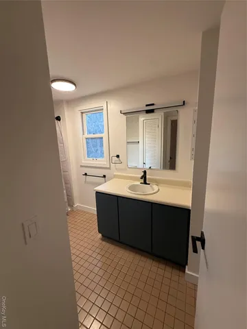 a spacious bathroom with a bathtub sink and mirror